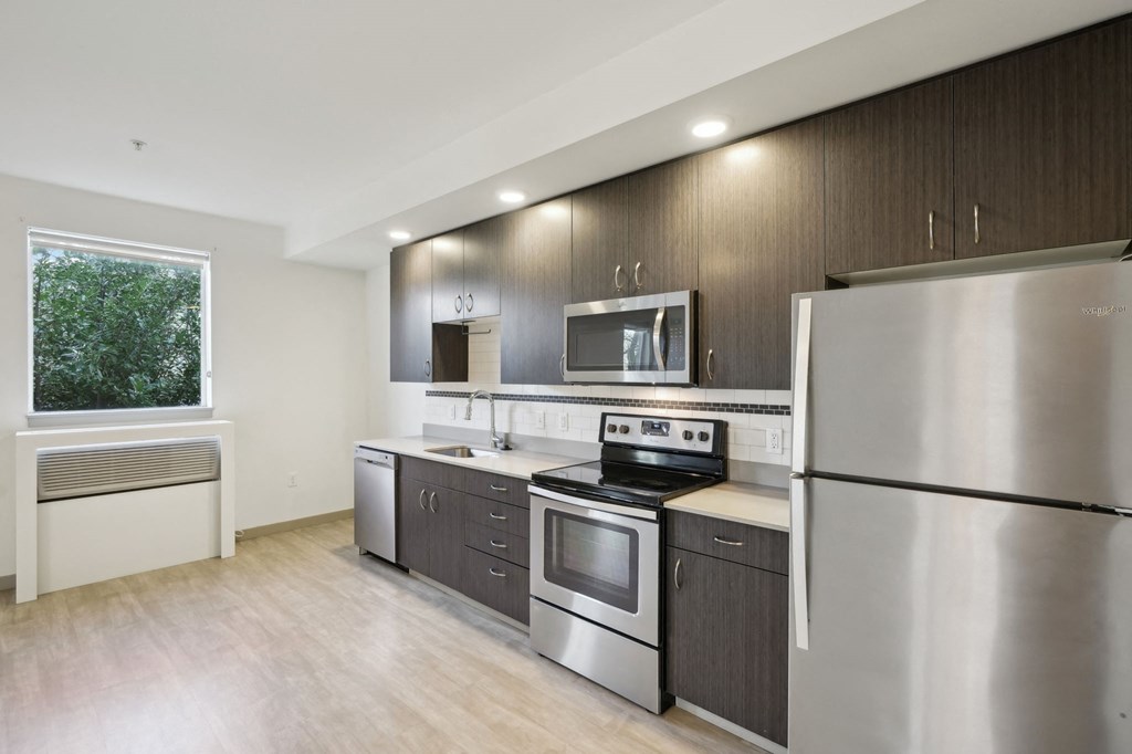 A modern kitchen with stainless steel appliances and wooden cabinets.