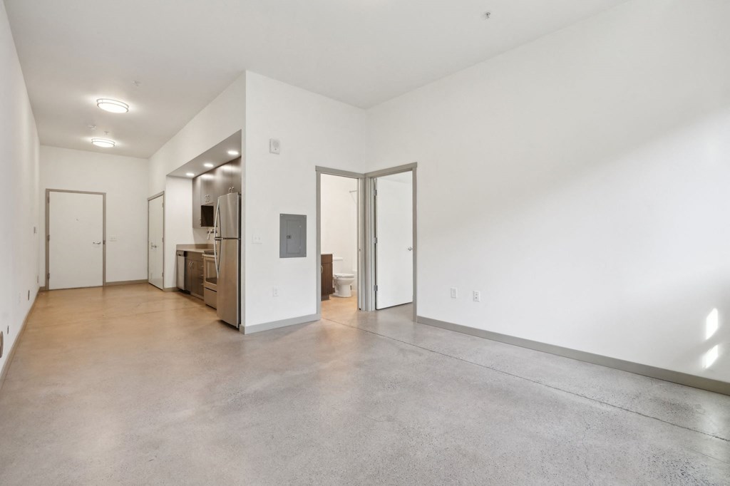 A large empty room with a door on the left and a door on the right.