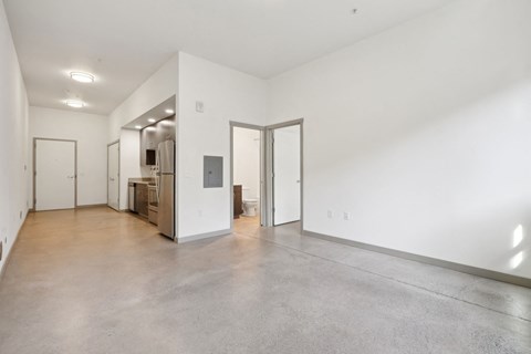 A large empty room with a door on the left and a door on the right.