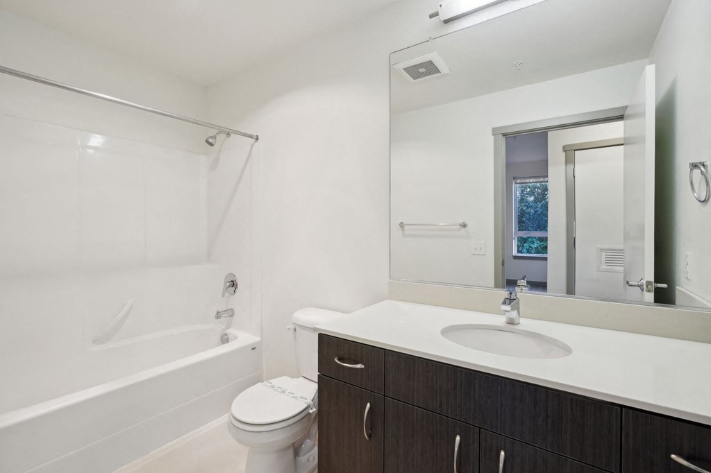 A white bathroom with a toilet, sink, and bathtub.