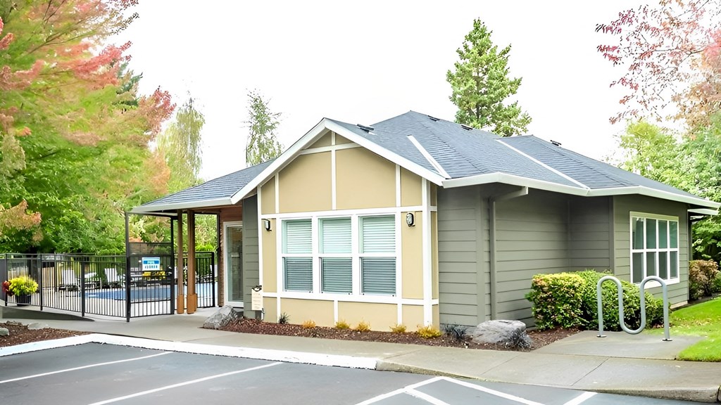 A small building with a grey roof and a white door.