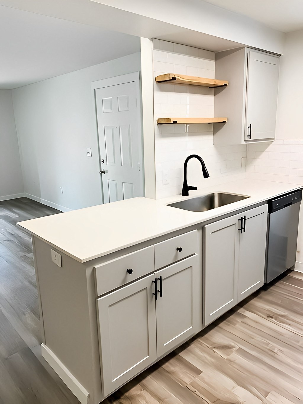 A kitchen with white cabinets and a sink.