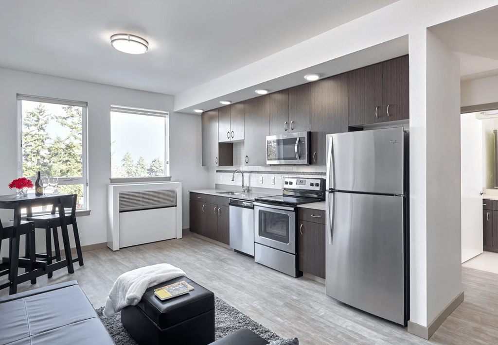 A modern kitchen with stainless steel appliances and wooden cabinets.