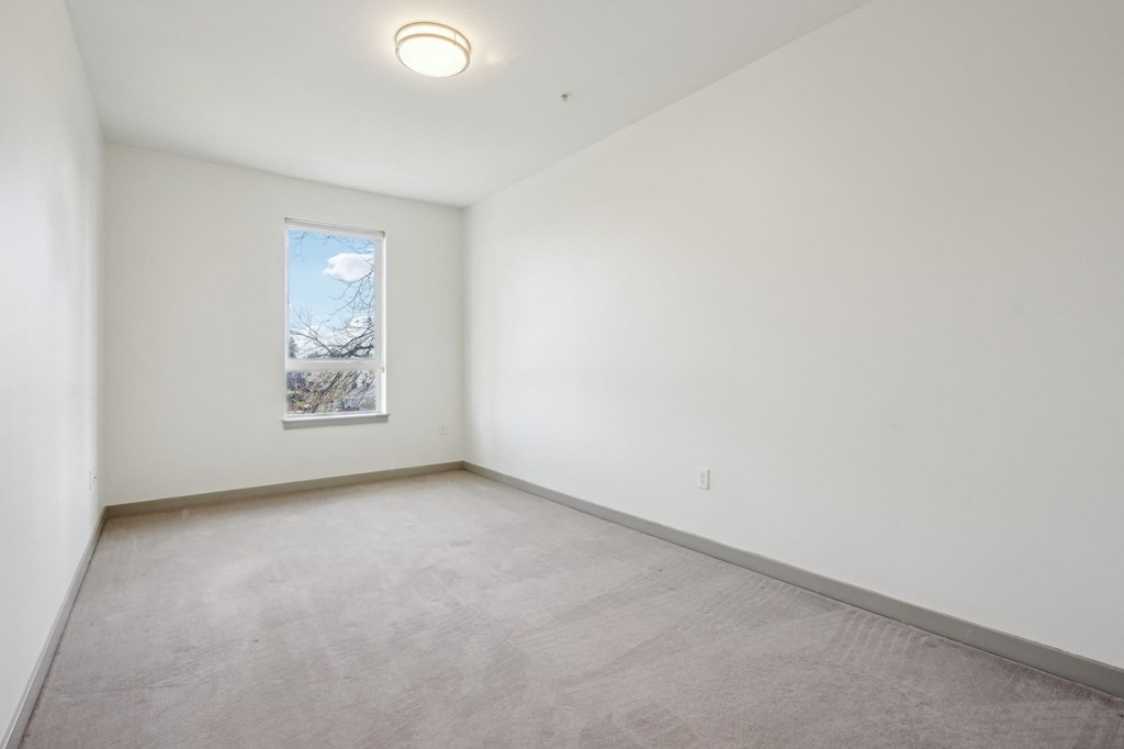 A room with a window and a poster on the wall.