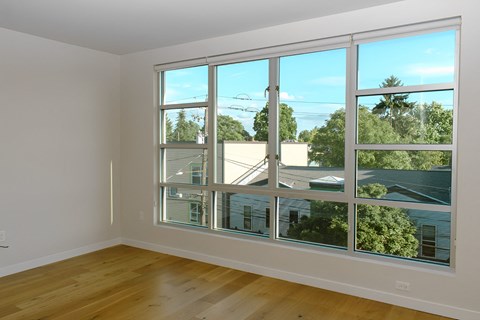 A room with a large window overlooking a residential area.