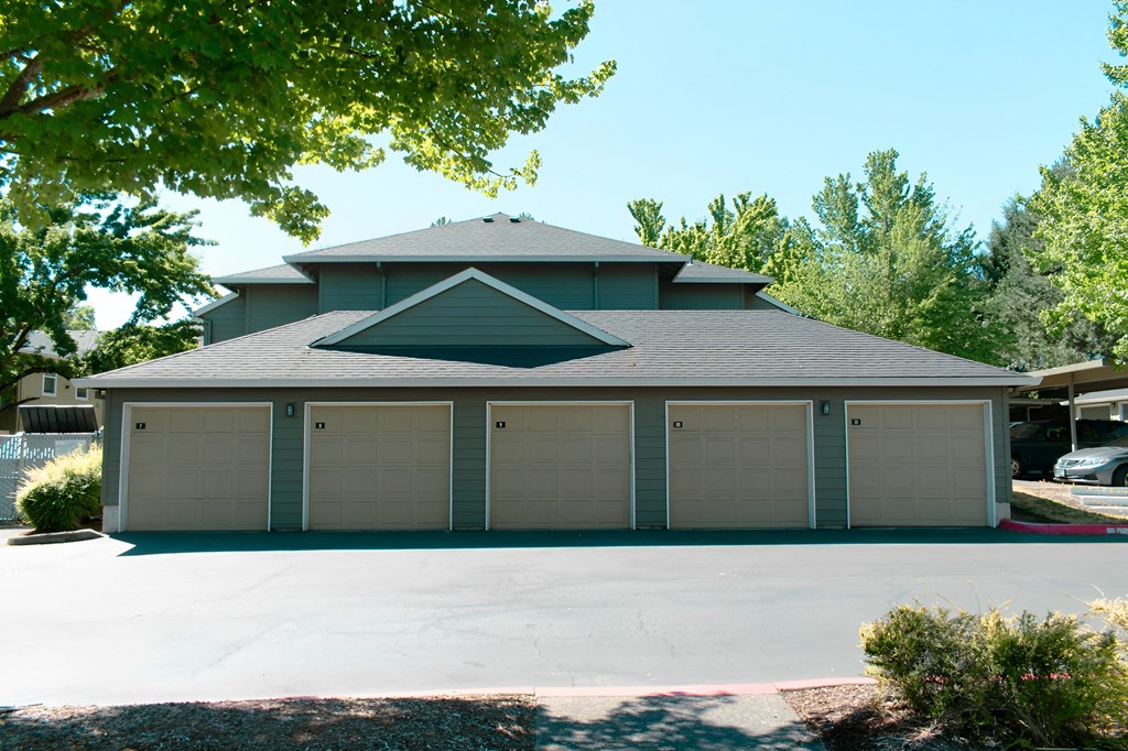 A house with a grey roof and a garage with four doors.