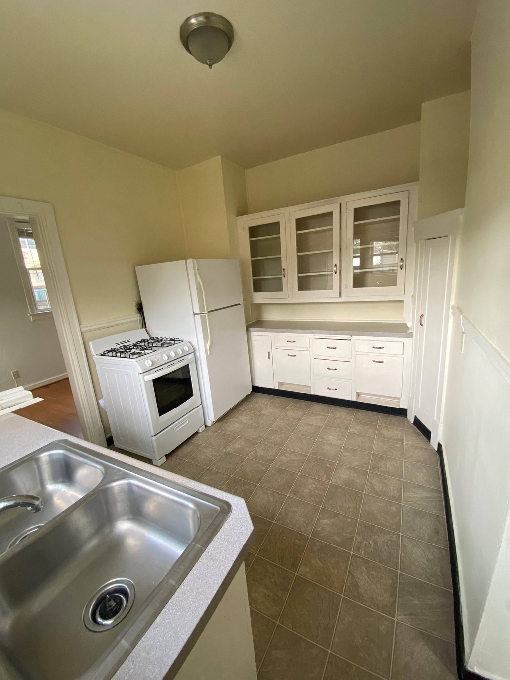a kitchen with white cabinets and a stainless steel sink