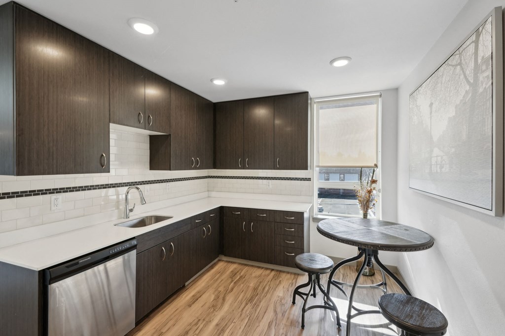 A modern kitchen with dark wood cabinets and a white countertop.