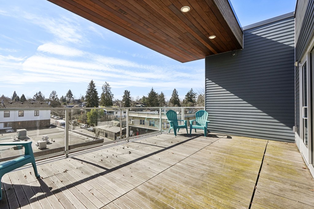 A wooden deck with two chairs and a table.