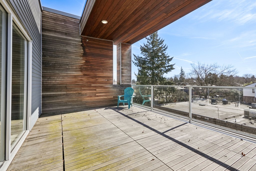 A wooden deck with a blue chair and a wooden house.