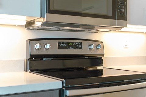 A modern stove top with a digital display is installed in a kitchen.