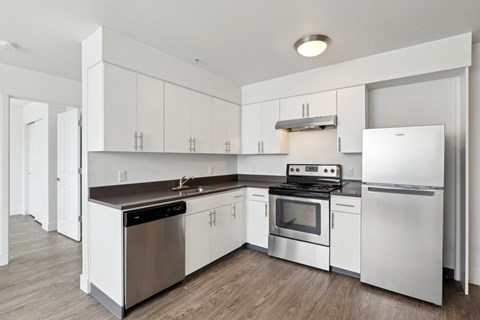 A modern kitchen with white cabinets and stainless steel appliances.