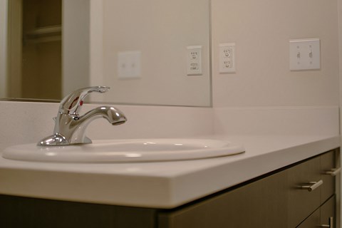 A white sink with a chrome faucet in a bathroom.