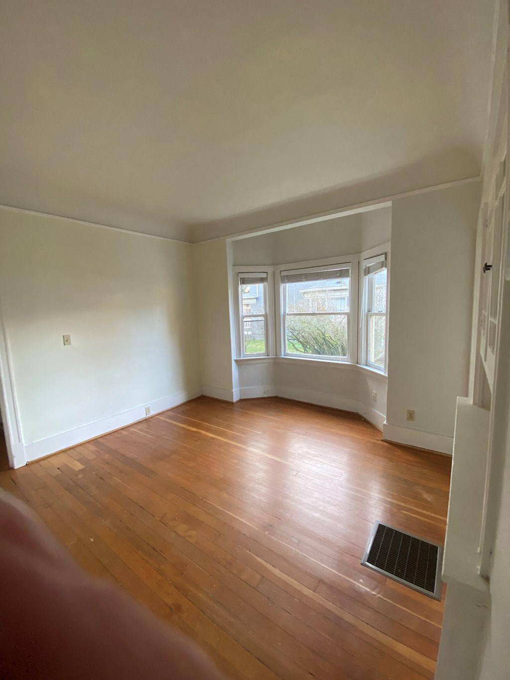 an empty room with a window and radiator