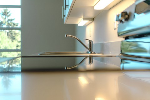 A close up of a kitchen sink with a faucet.