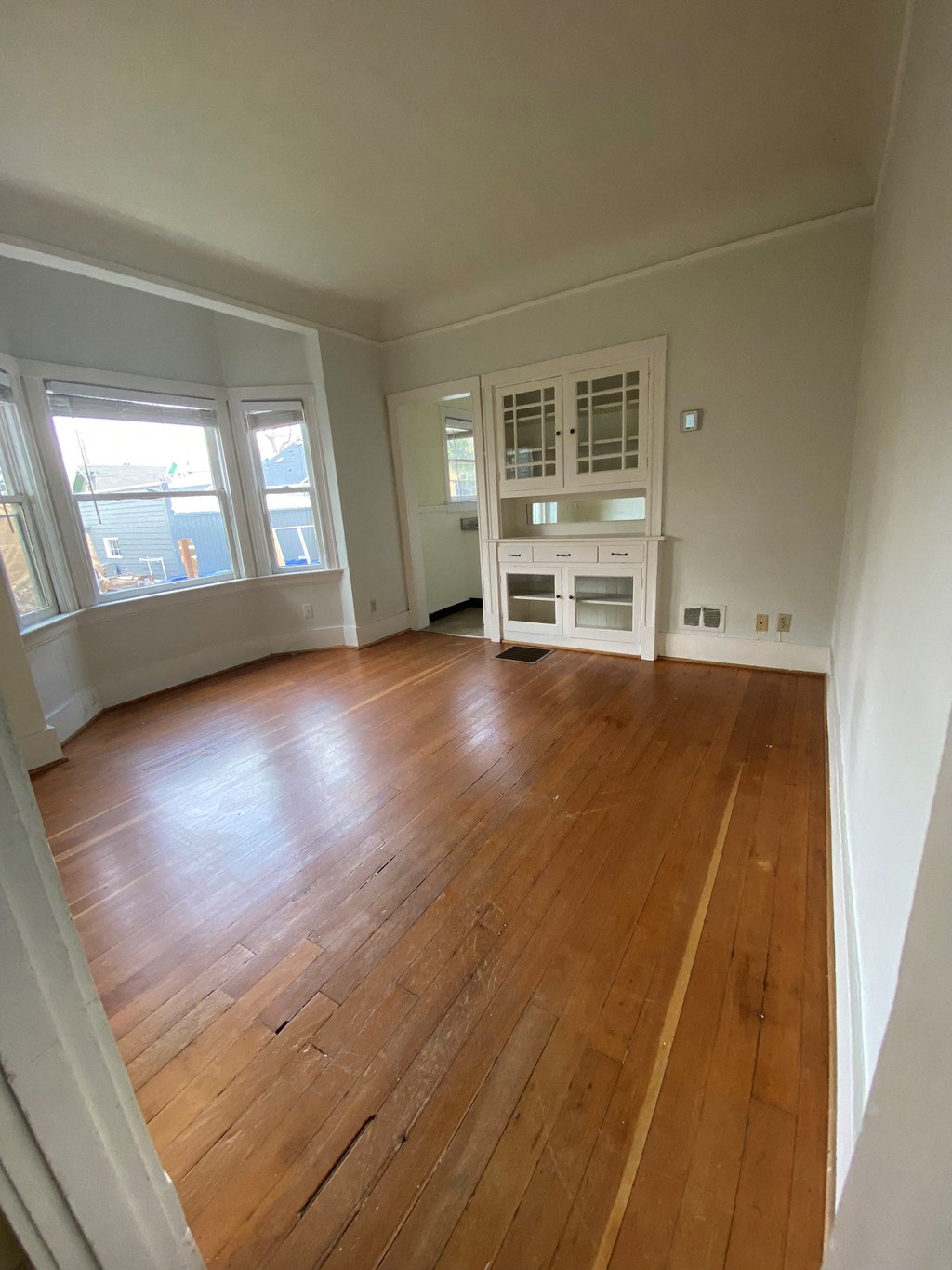an empty living room with a hardwood floor