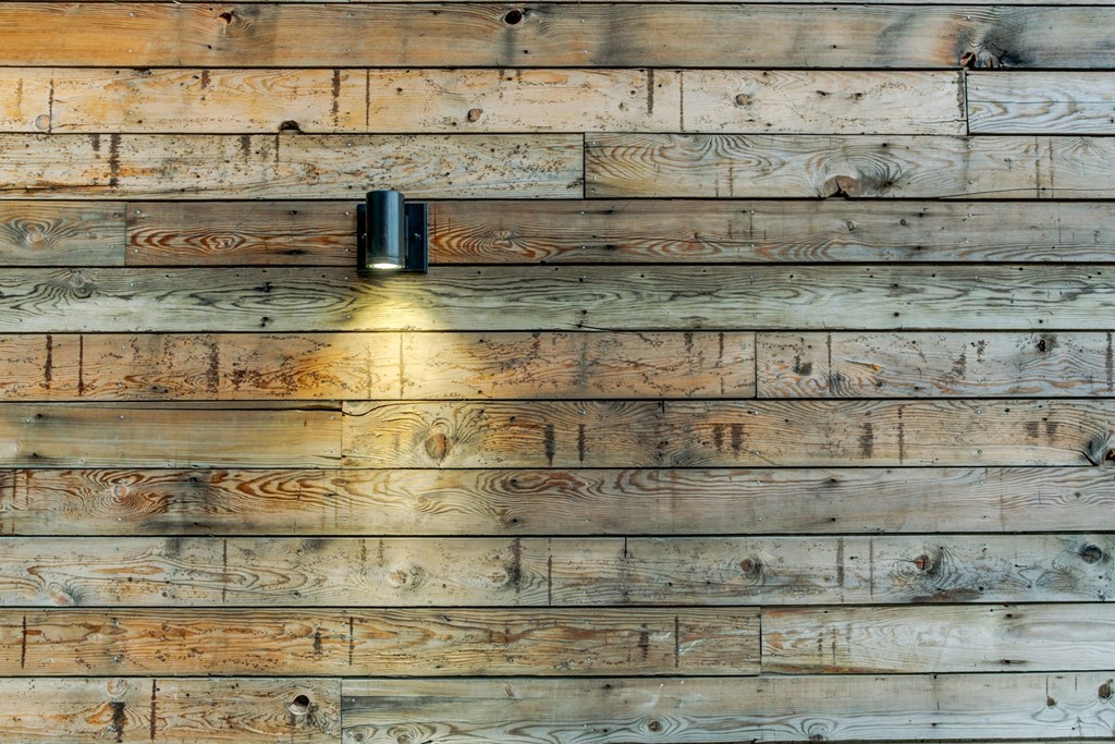 the wall is made of reclaimed wood with a light on it