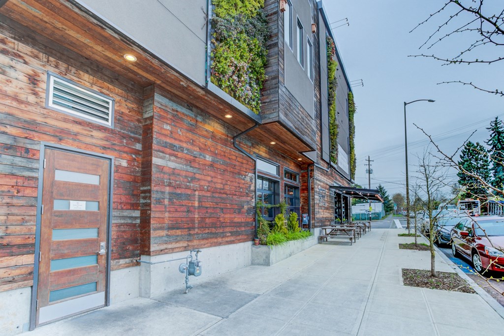the side of a building with a sidewalk and a parking meter