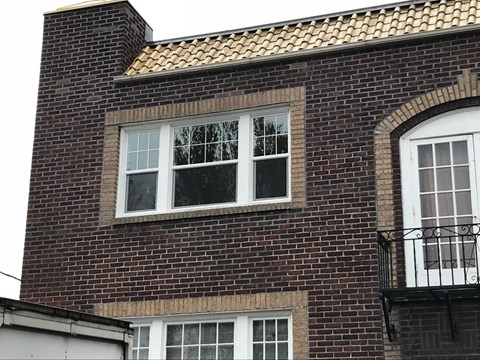 A brick building with a window and a balcony.