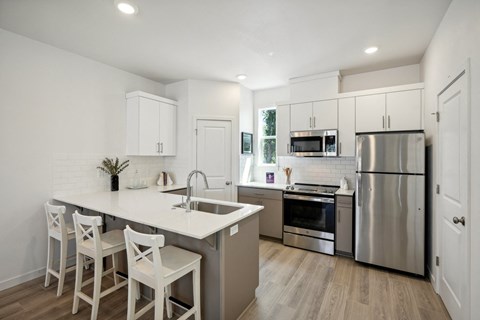 a kitchen with a large island and stainless steel appliances