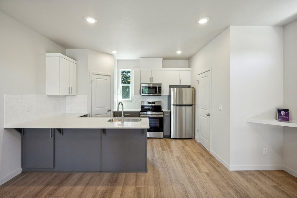 a kitchen with white cabinets and stainless steel appliances