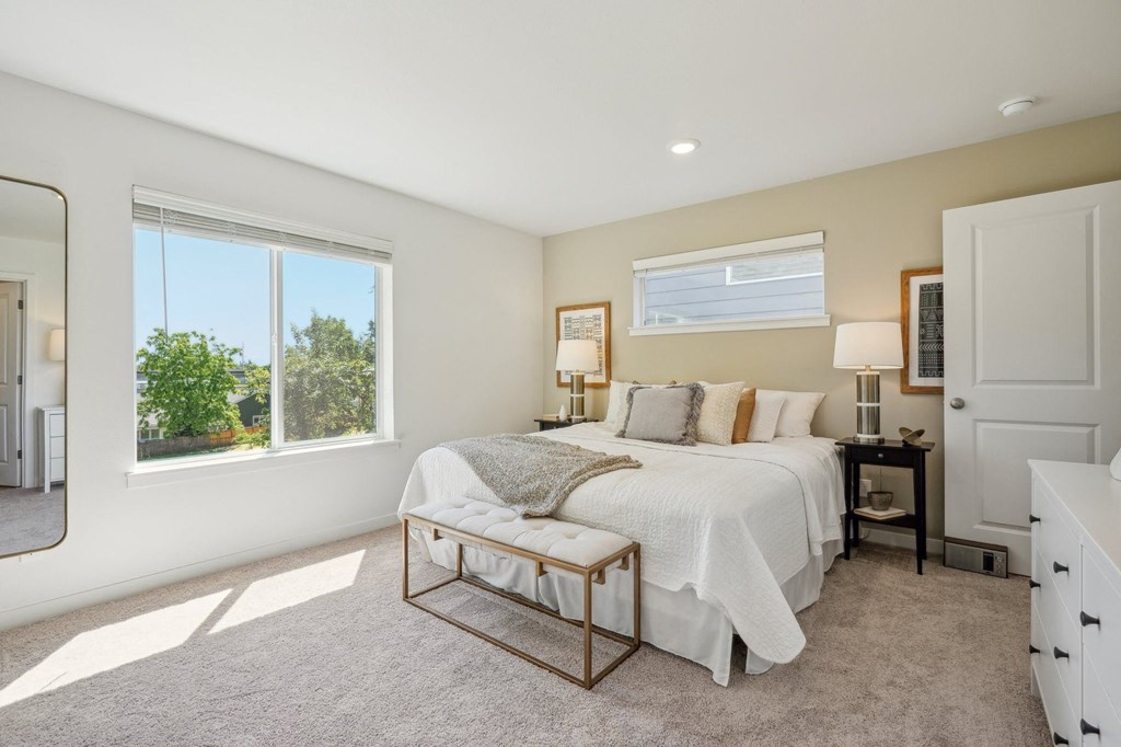 a bedroom with a bed and two windows