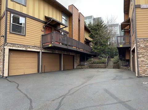 A parking lot in front of a building with a balcony.