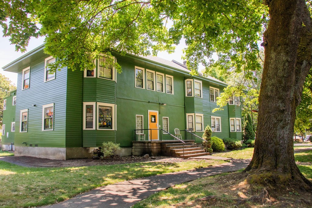 a green house with trees in front of it