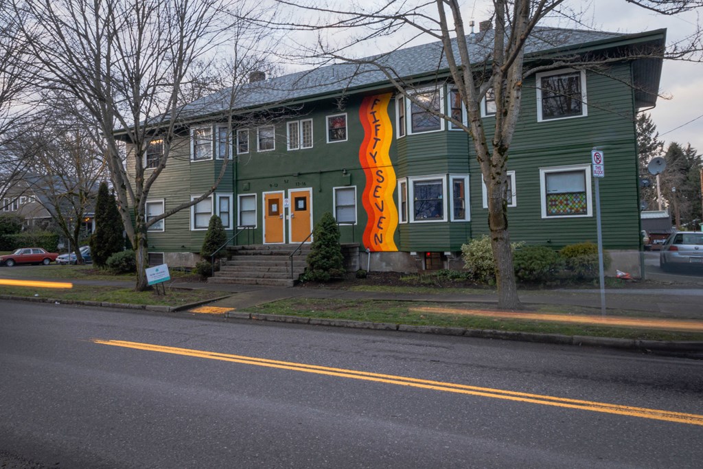 a green house with a flag on the side of it