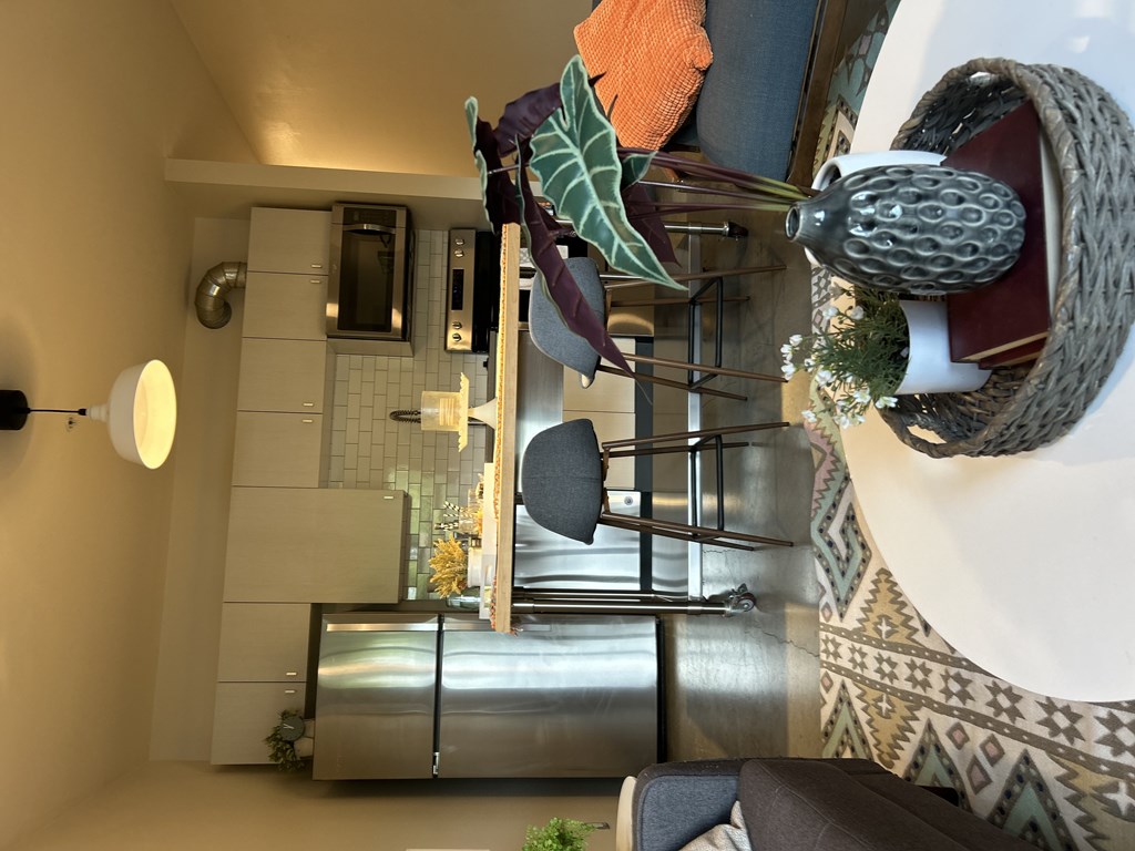 A kitchen with a white counter and a stainless steel refrigerator.