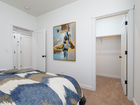 A bedroom with a bed and a painting on the wall.