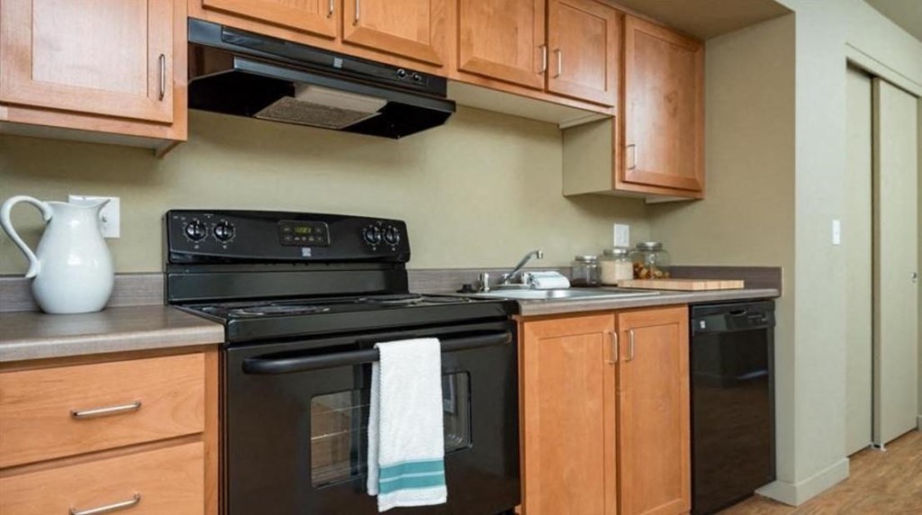 a kitchen with black appliances and wooden cabinets