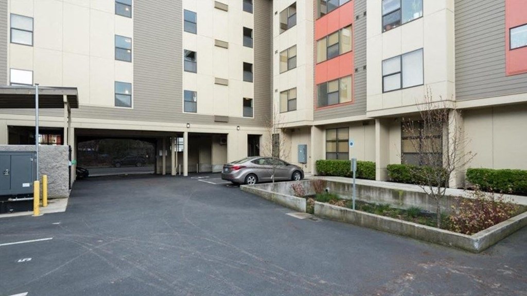a car parked in a parking lot in front of an apartment building