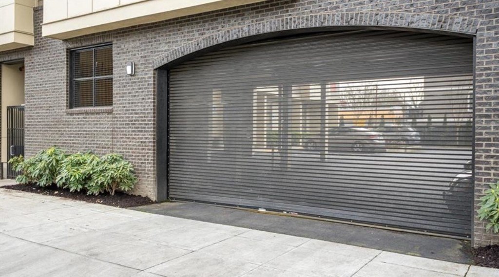 a closed garage door on the side of a brick building