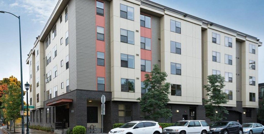 a large apartment building with cars parked in front of it