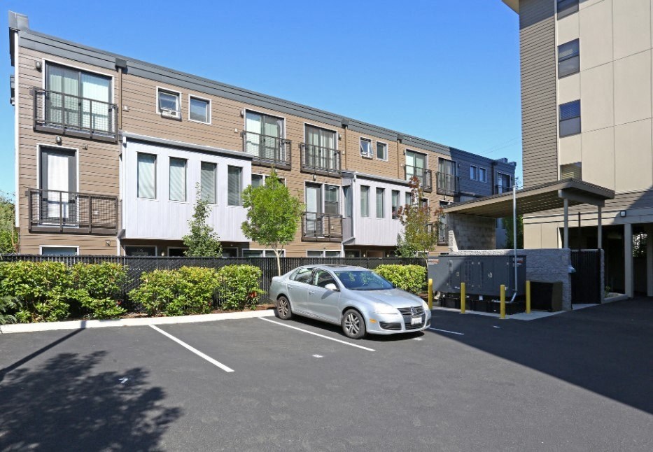 a car parked in a parking lot in front of an apartment building