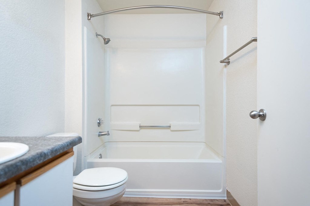 A white bathroom with a toilet, sink, and bathtub.