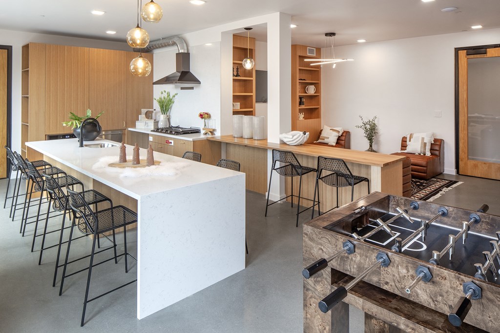 the kitchen and dining area of a modern house with a large white island and chairs at The Weidler in Portland, OR 97209