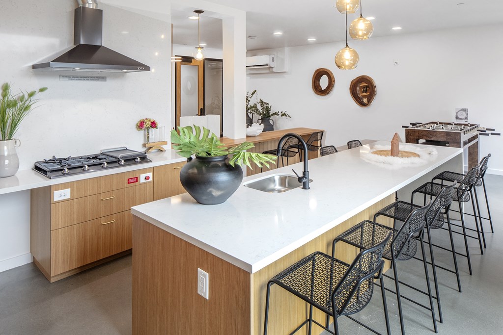 a large kitchen with an island and black bar stools at The Weidler in Portland, OR 97209