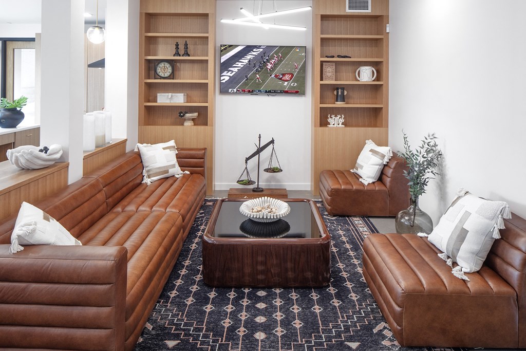 a living room with brown leather couches and a table at The Weidler in Portland, OR 97209