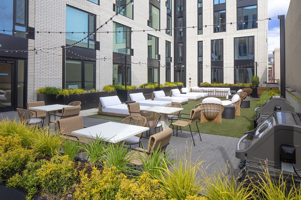 an outdoor patio area with tables and chairs at an apartment building at The Weidler in Portland, OR 97209