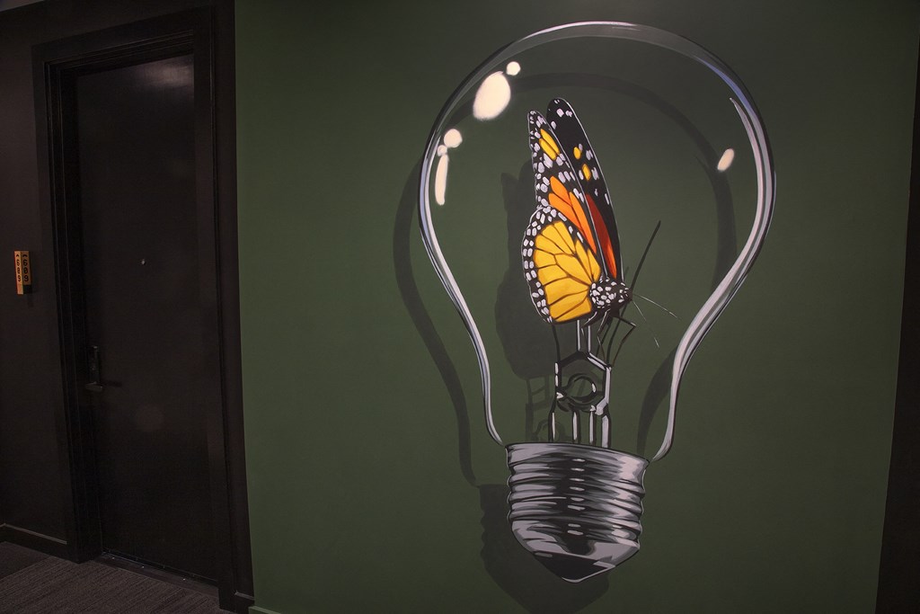 a painting of a butterfly inside of a light bulb at The Weidler in Portland, OR 97209