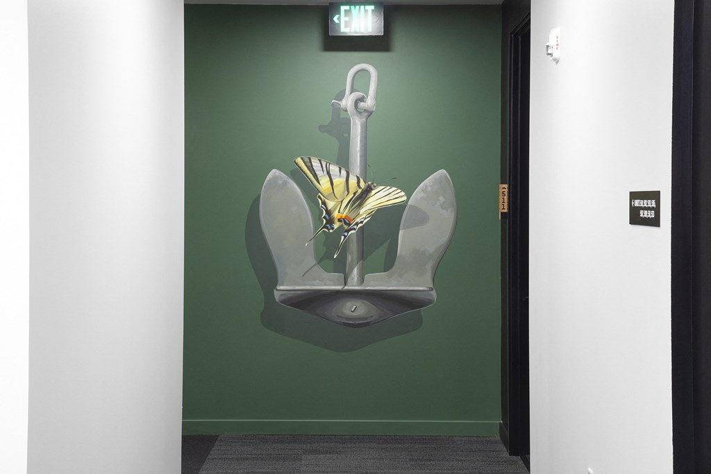 a painting of a flower on a wall next to a urinal at The Weidler in Portland, OR 97209