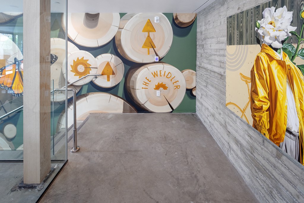 a hallway with a statue of a monk in a yellow robe and a wall with at The Weidler in Portland, OR 97209