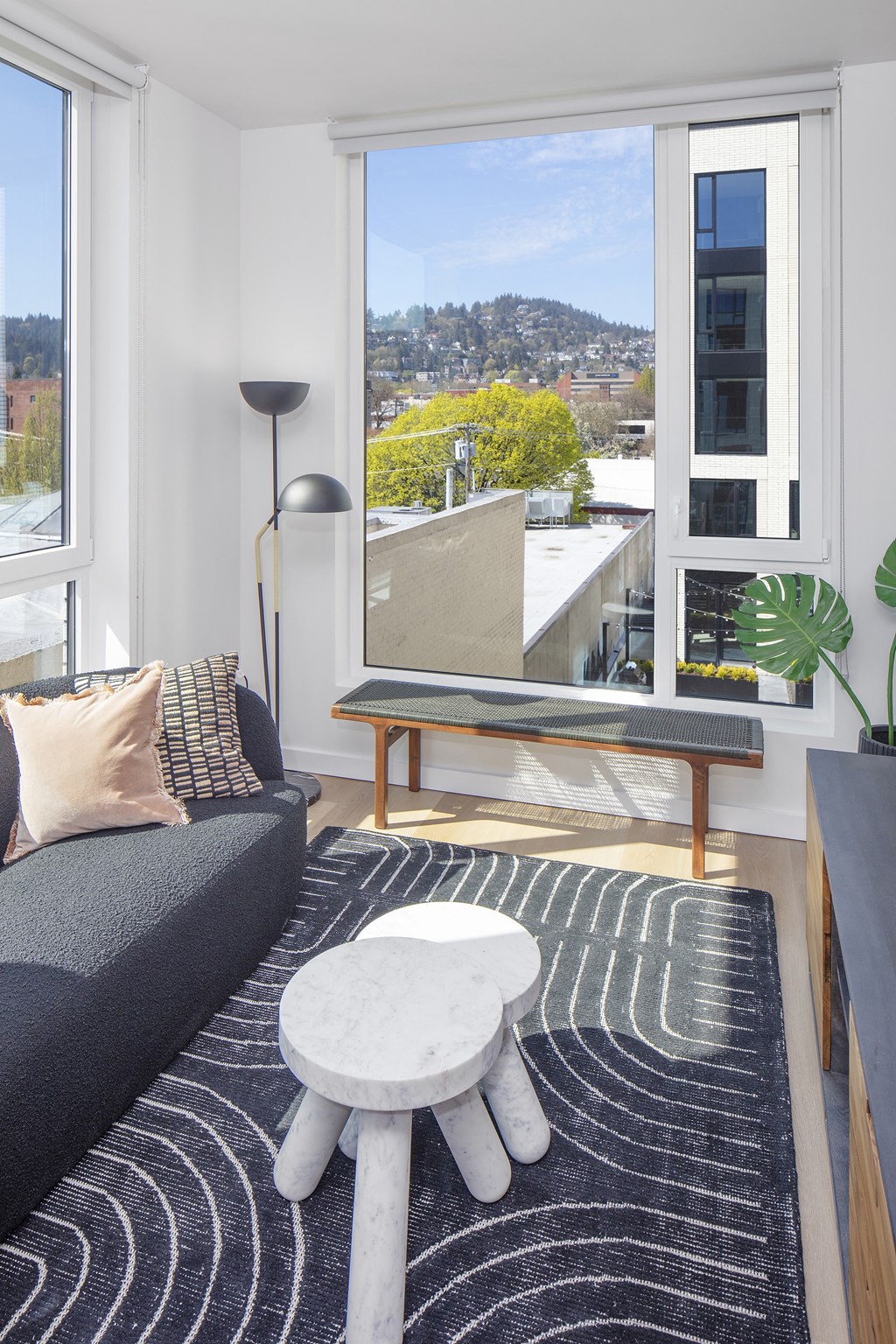 a living room with a couch and a coffee table and a view of the city at The Weidler in Portland, OR 97209