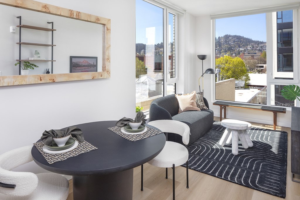 a dining room with a black table and chairs and a large window at The Weidler in Portland, OR 97209