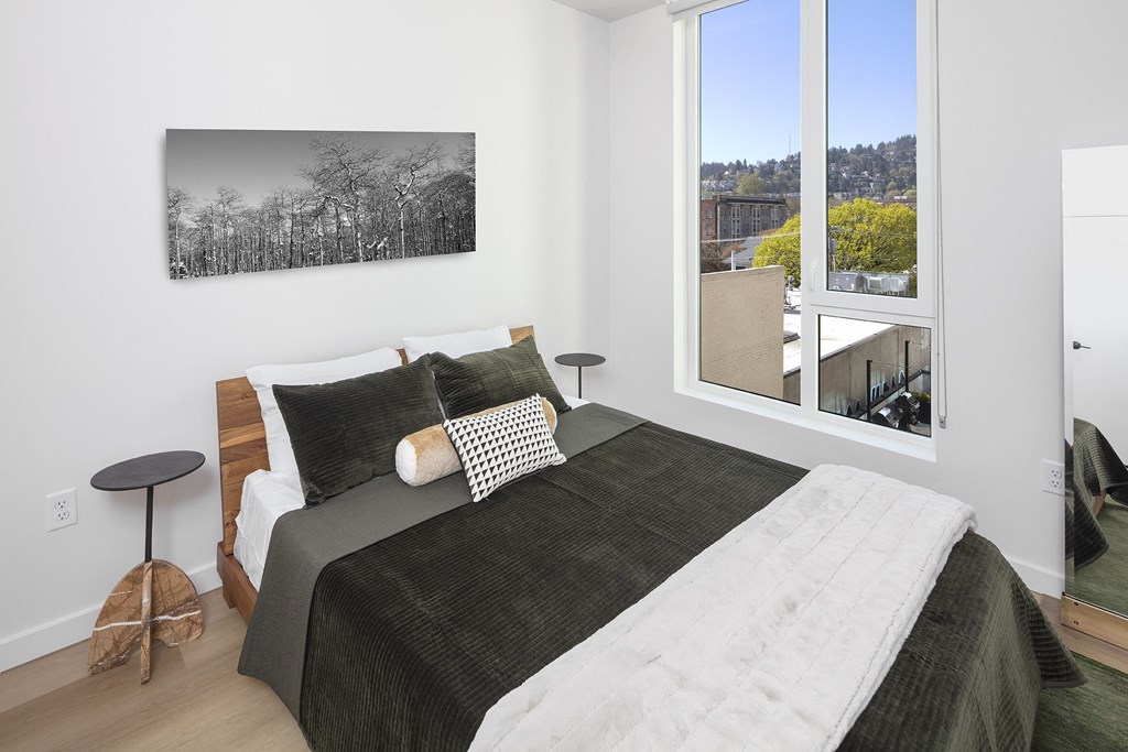a bedroom with a bed and a large window at The Weidler in Portland, OR 97209
