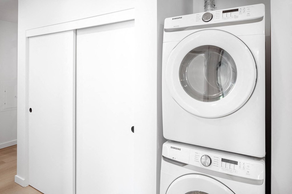 a white washer and dryer in a white laundry room at The Weidler in Portland, OR 97209