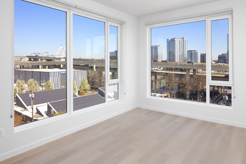 a living room with four windows and a city view at The Weidler in Portland, OR 97209