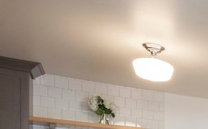A kitchen with a refrigerator, sink, and cabinets.